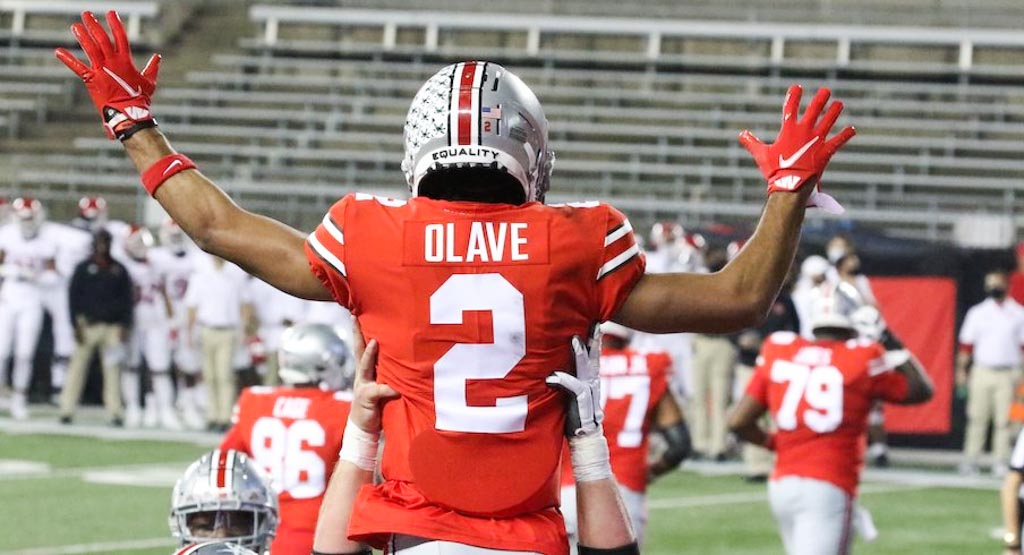 Ohio State Buckeyes wide receiver Chris Olave being hoisted in the air by a teammate.