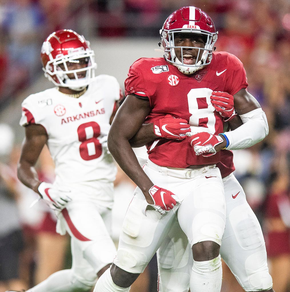 Top NFL prospect Christian Harris of Alabama being hugged by teammate.