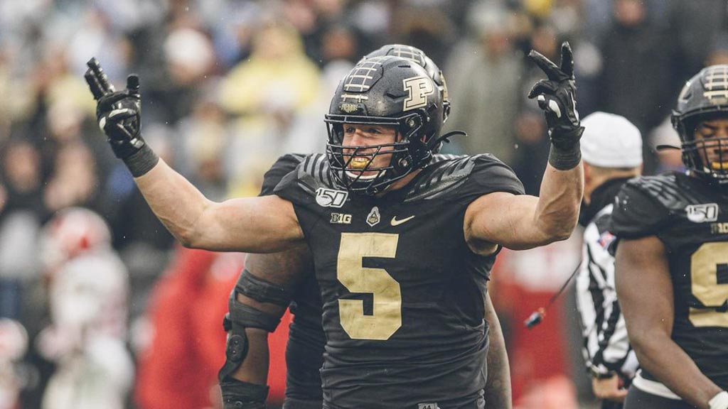 Purdue Edge rusher George Karlaftis celebrates with his hands toward the sky.