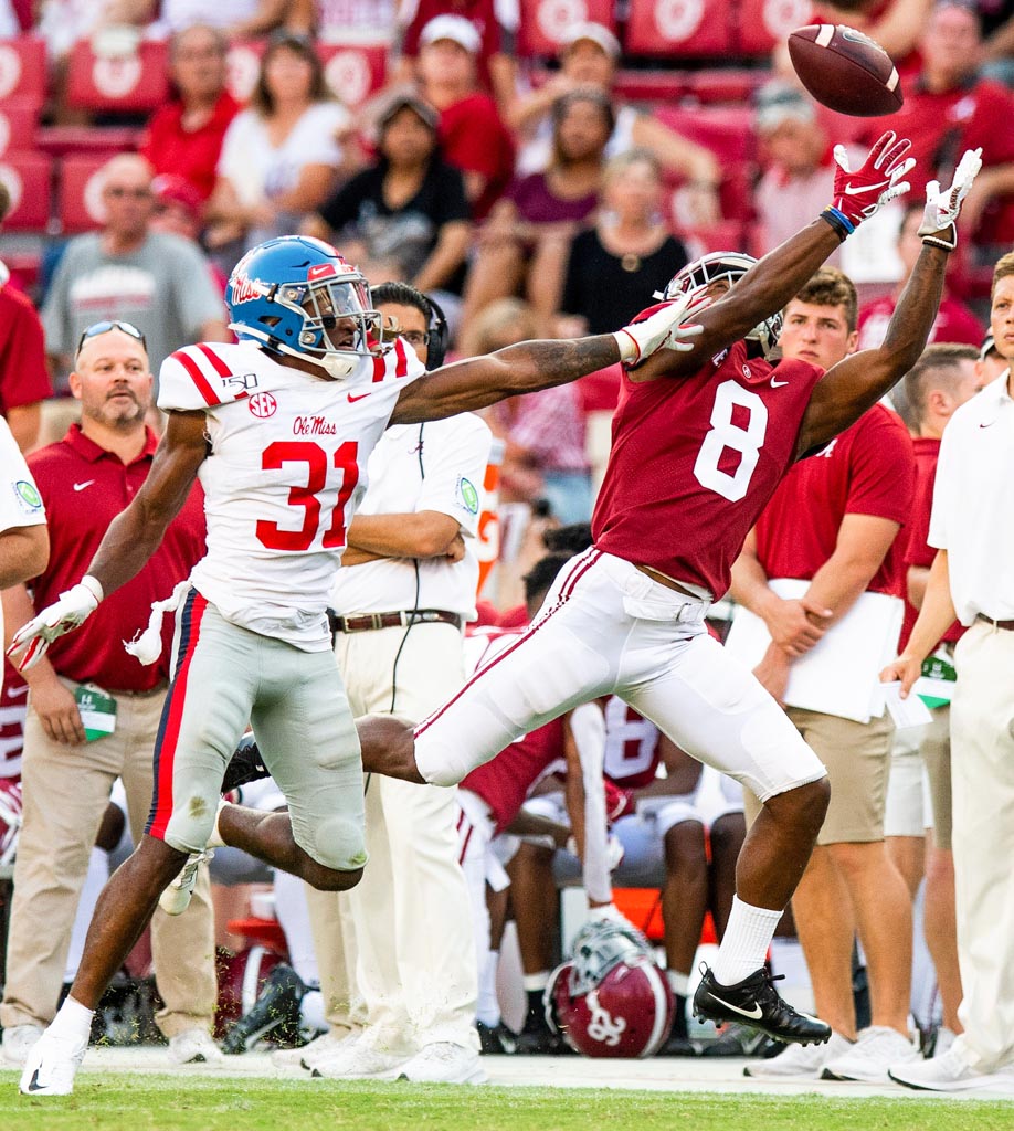 Alabama receiver John Metchie III reaches for a throw just outside the reach of an Ole Miss defender.