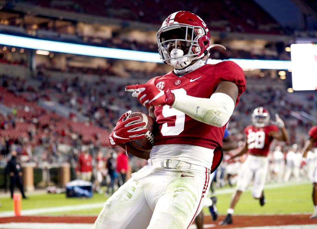 Alabama Safety Jordan Battle holds ball in endzone while wearing the crimson jersey adorning a white number 9.
