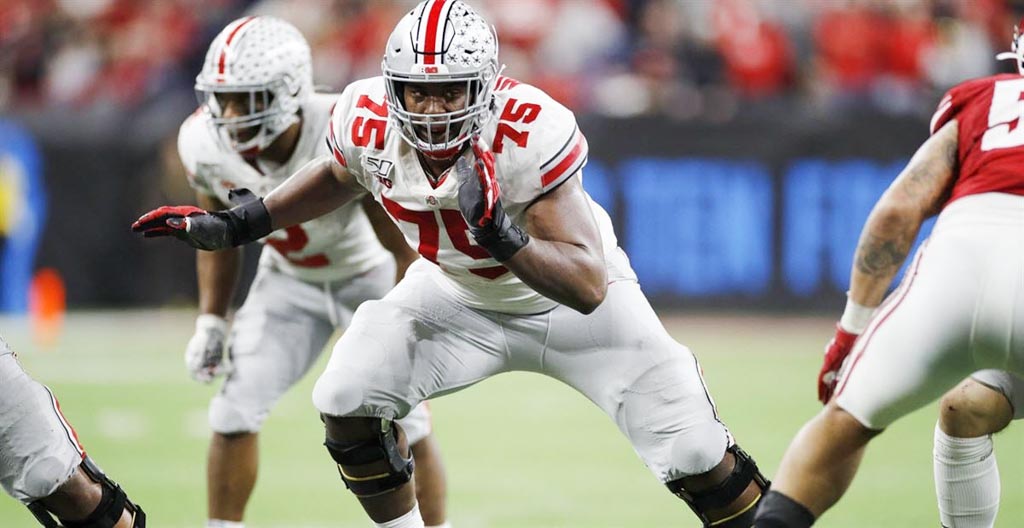Ohio State guard Thayer Munford wearing the white Buckeyes jersey prepares to block a defender.