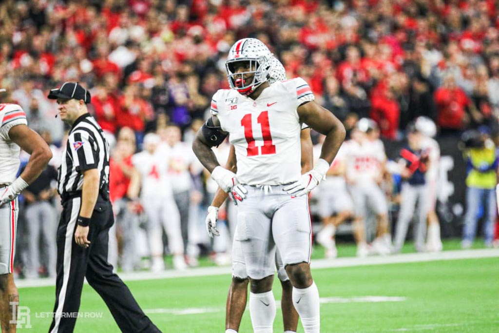 Tyreke Smith of Ohio State stands with his hands upon his hips while wearing white jersey adorning a red number 11.